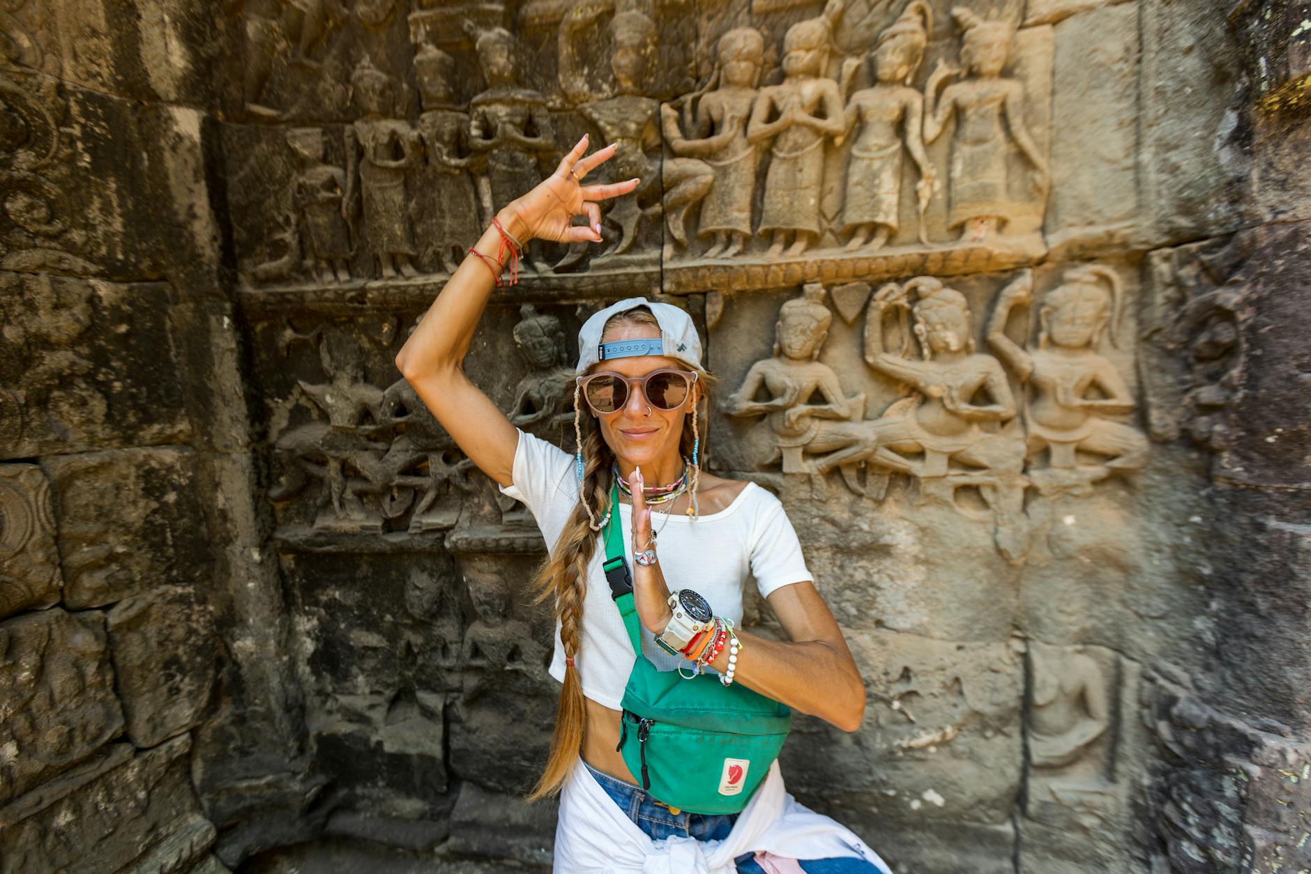 Jak przygotować się do pierwszej podróży do Azji Południowo-Wschodniej – praktyczny poradnik dla początkujących Podróżniczka przed rzeźbioną ścianą świątyni Angkor Wat w Kambodży
