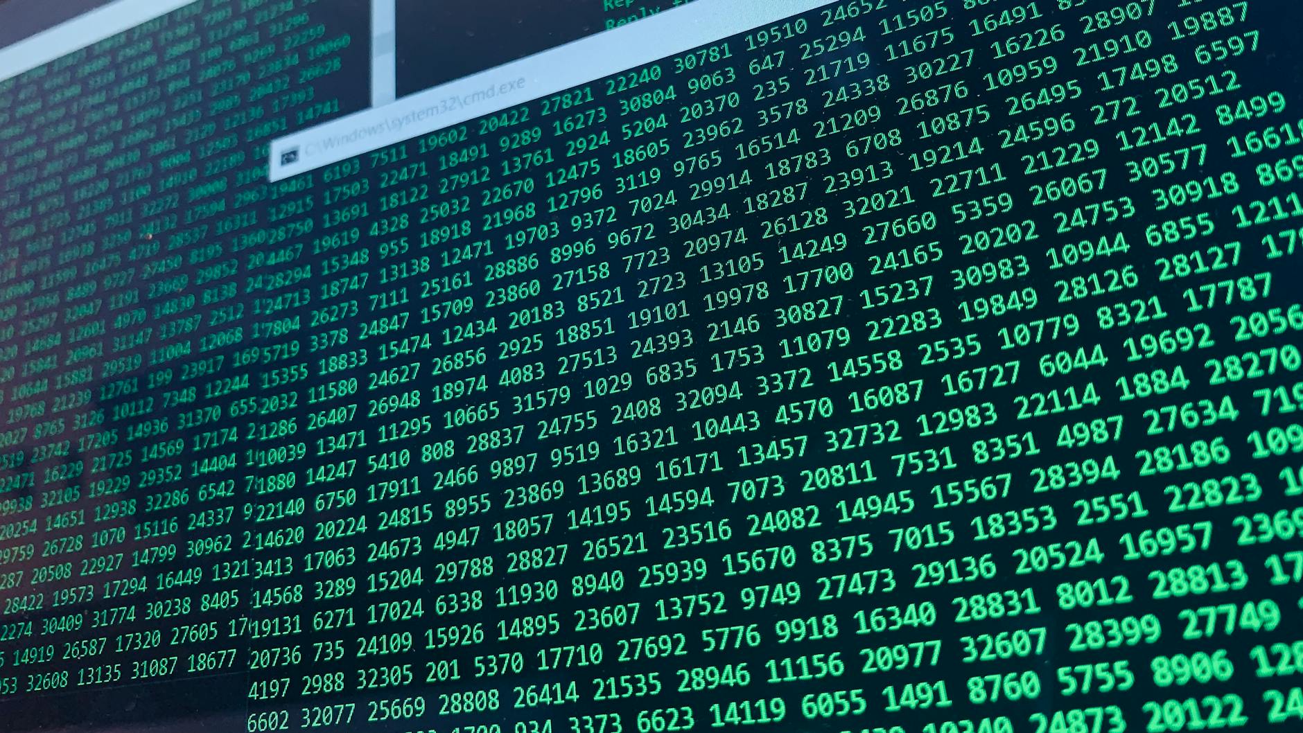 Zielone cyfry binarne na ekranie komputera symbolizujące analizę danych
