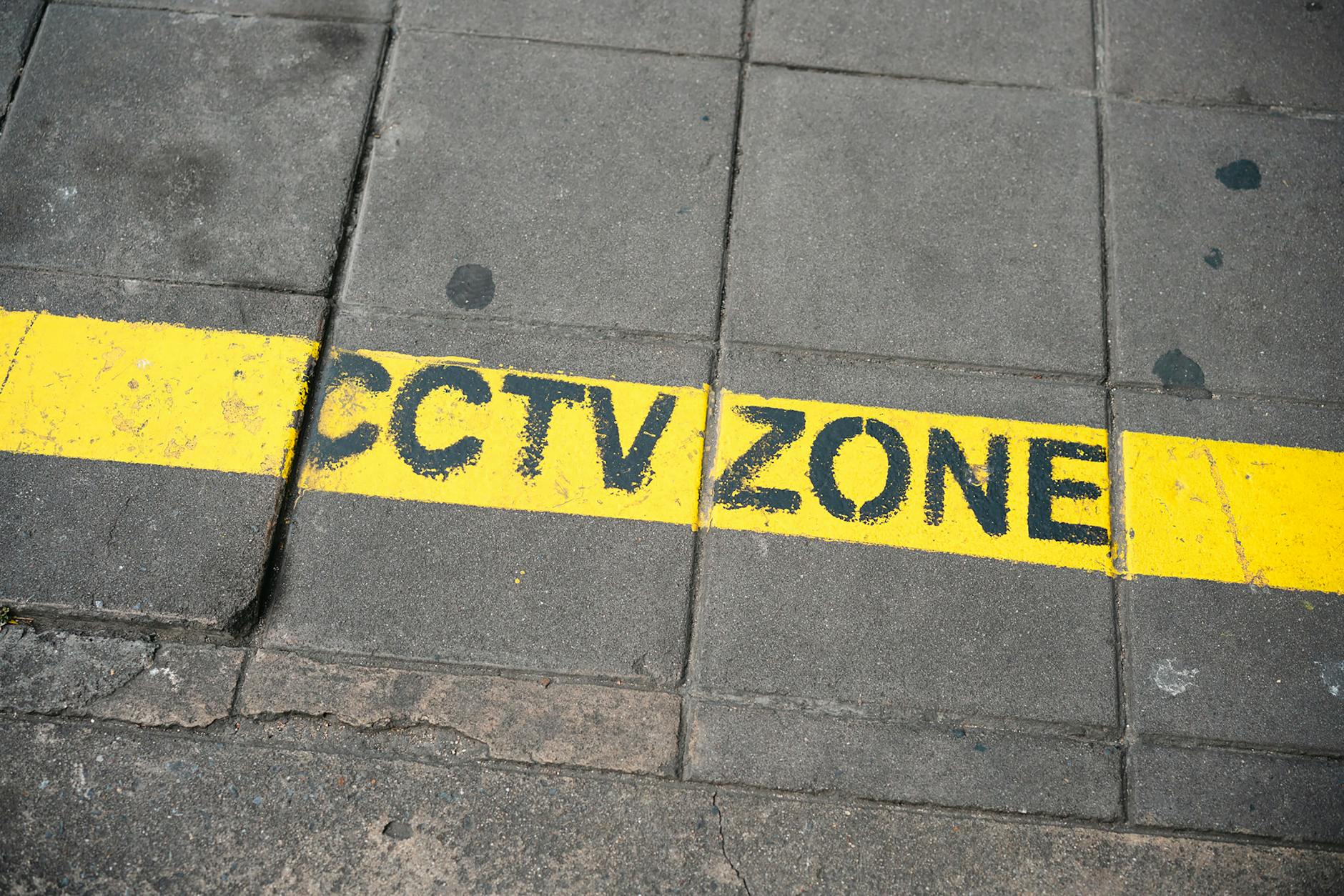 Znak ostrzegawczy strefa monitoringu CCTV przy miejskim chodniku